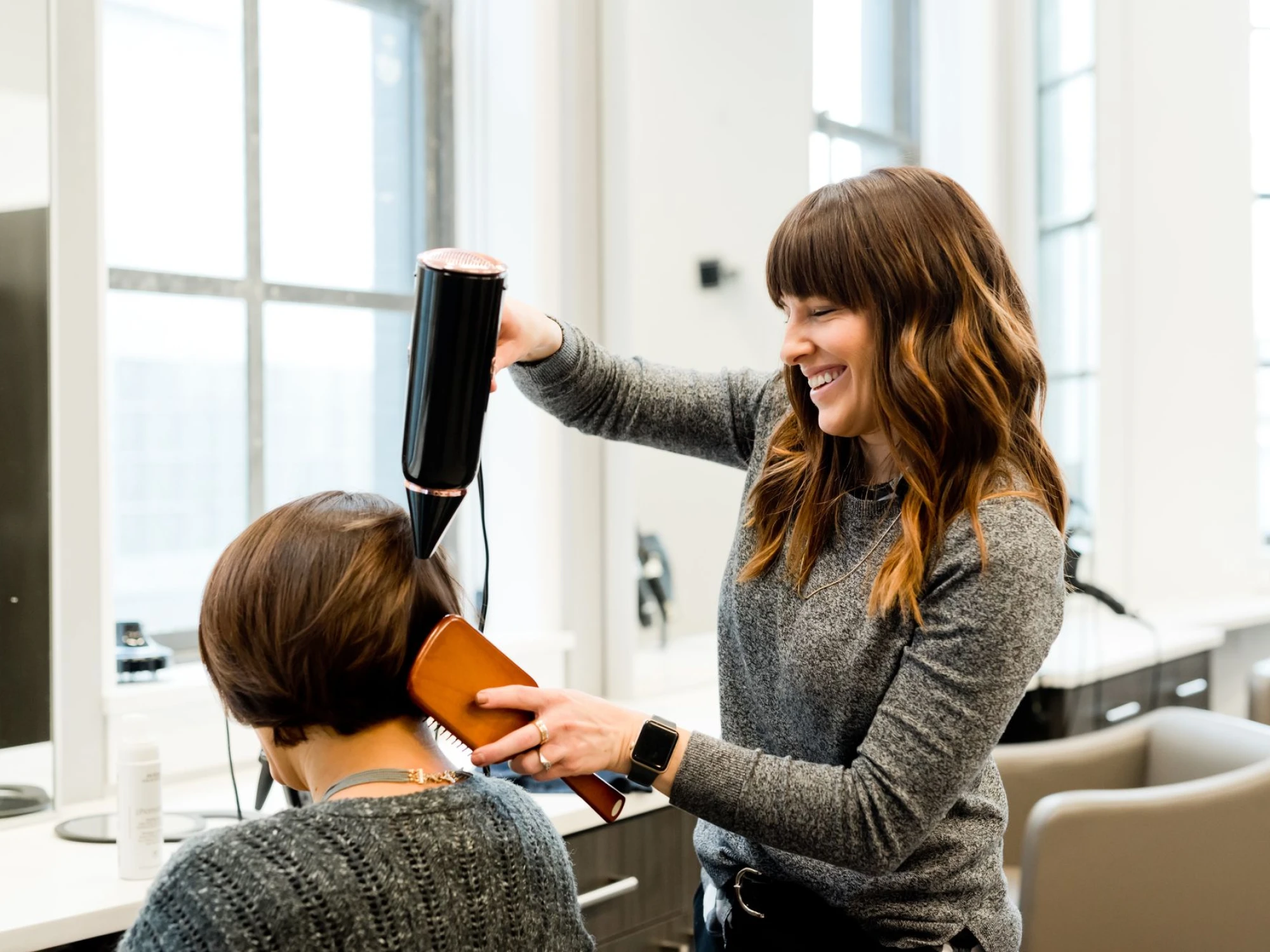 Hair stylist doing a blowout in salon